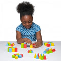 Colorful 3D wooden shapes blocks in geometric pieces on a tabletop with a child
