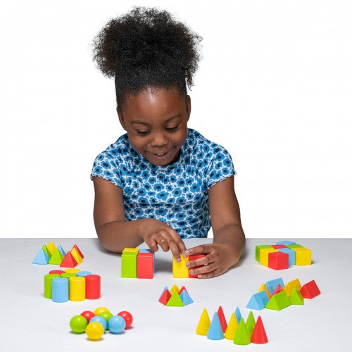Colorful 3D wooden shapes blocks in geometric pieces on a tabletop with a child