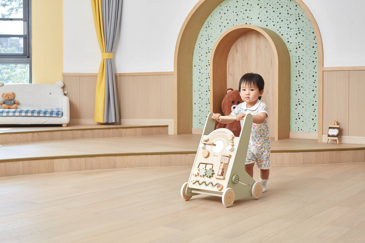 Activity baby walker with rainbow arch; toddler standing and holding the handle
