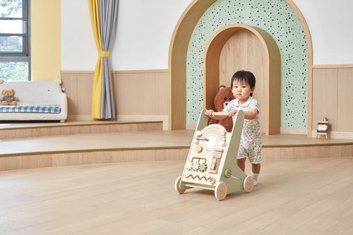 Activity baby walker with rainbow arch; toddler standing and holding the handle