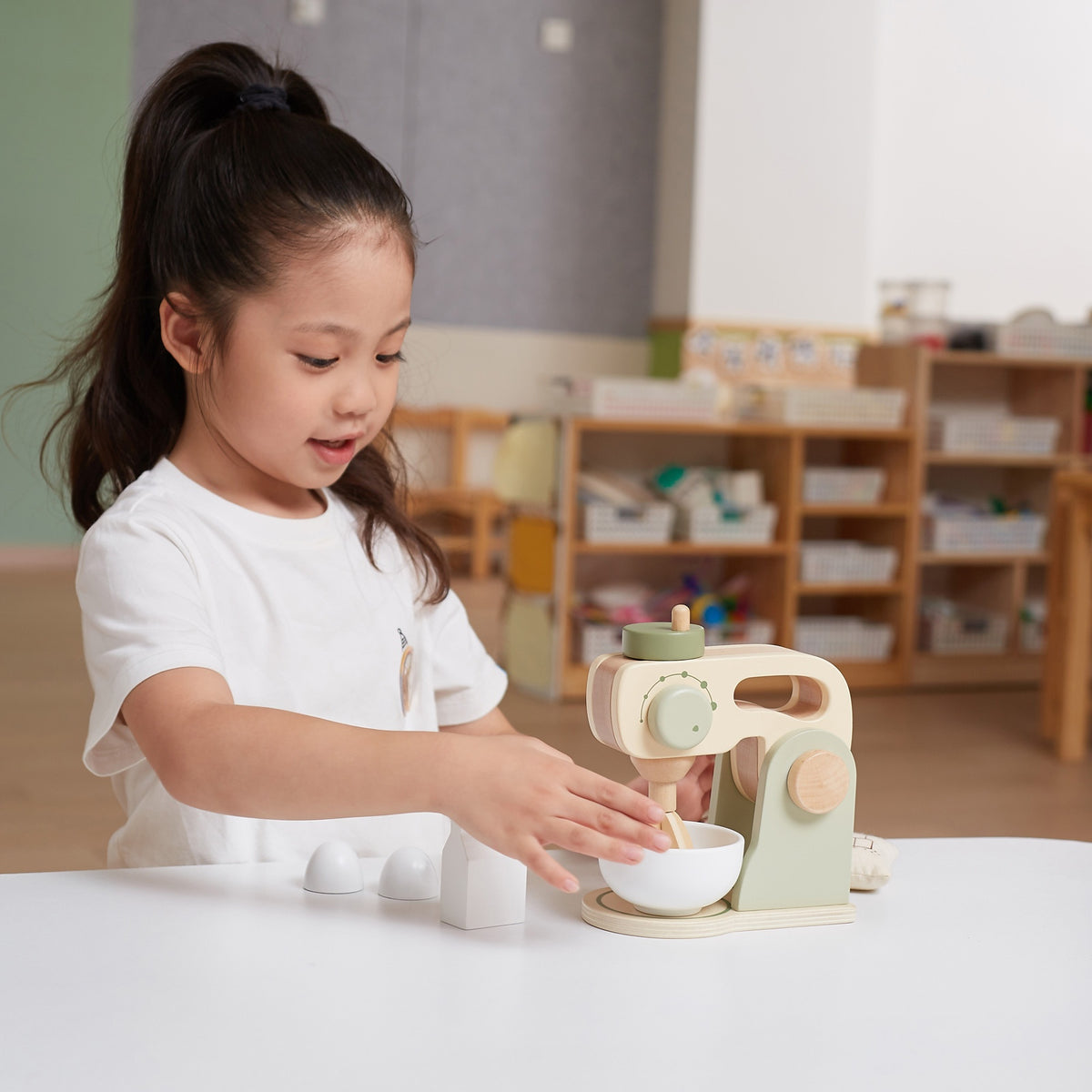Green-and-beige wooden toy coffee maker with removable cup and accessories