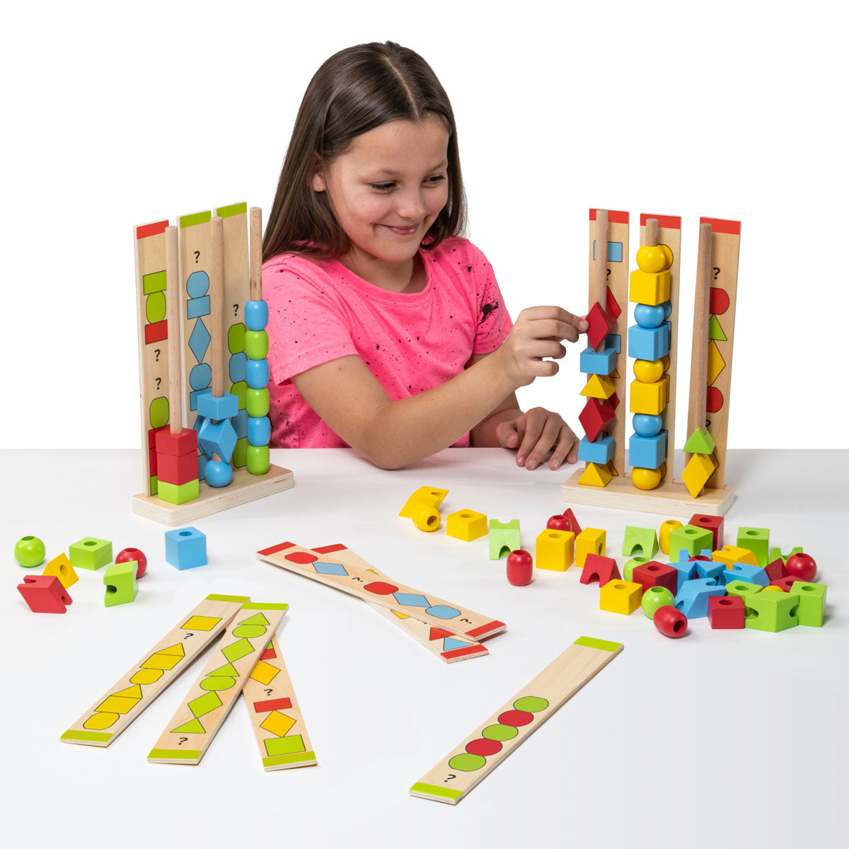 Colorful wooden block sequencing towers with shape pieces and bases, kid playing