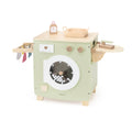 Mint green wooden toy washing machine with circular door, knobs, and accessories