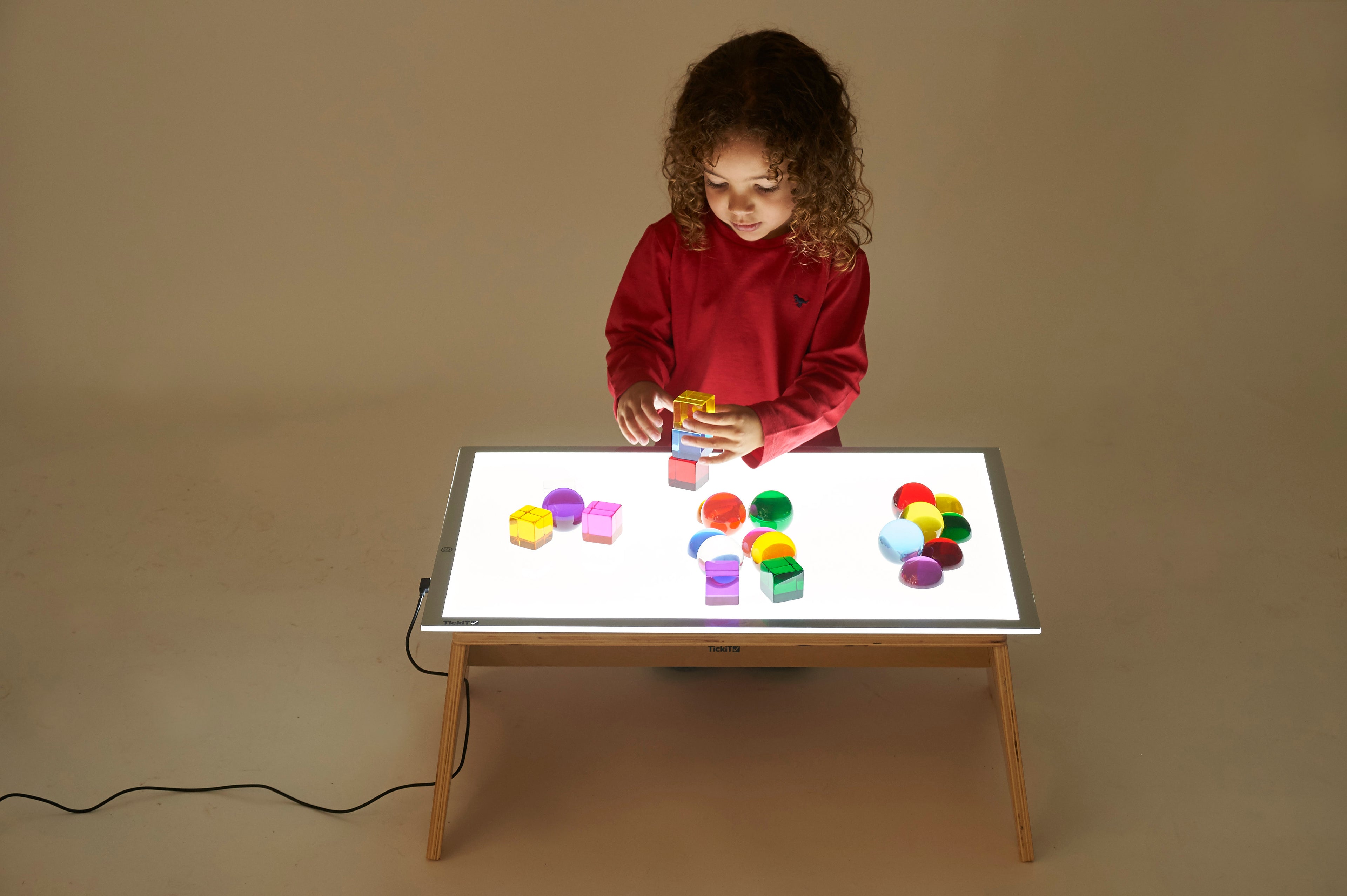 Kids’ color light panel with multicolored pieces arranged on the lit tray