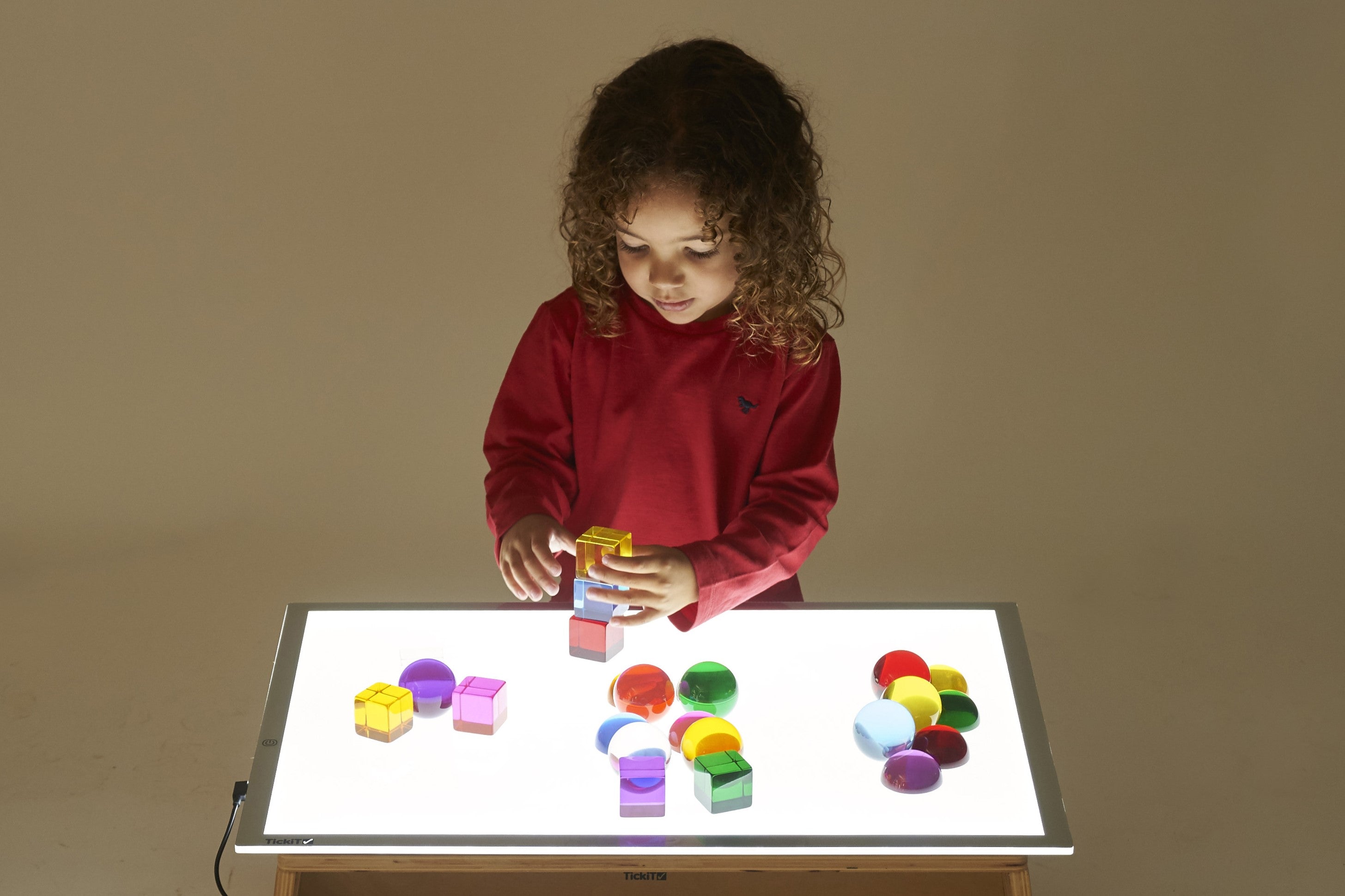 Light panel table with white glowing surface and colorful blocks on top
