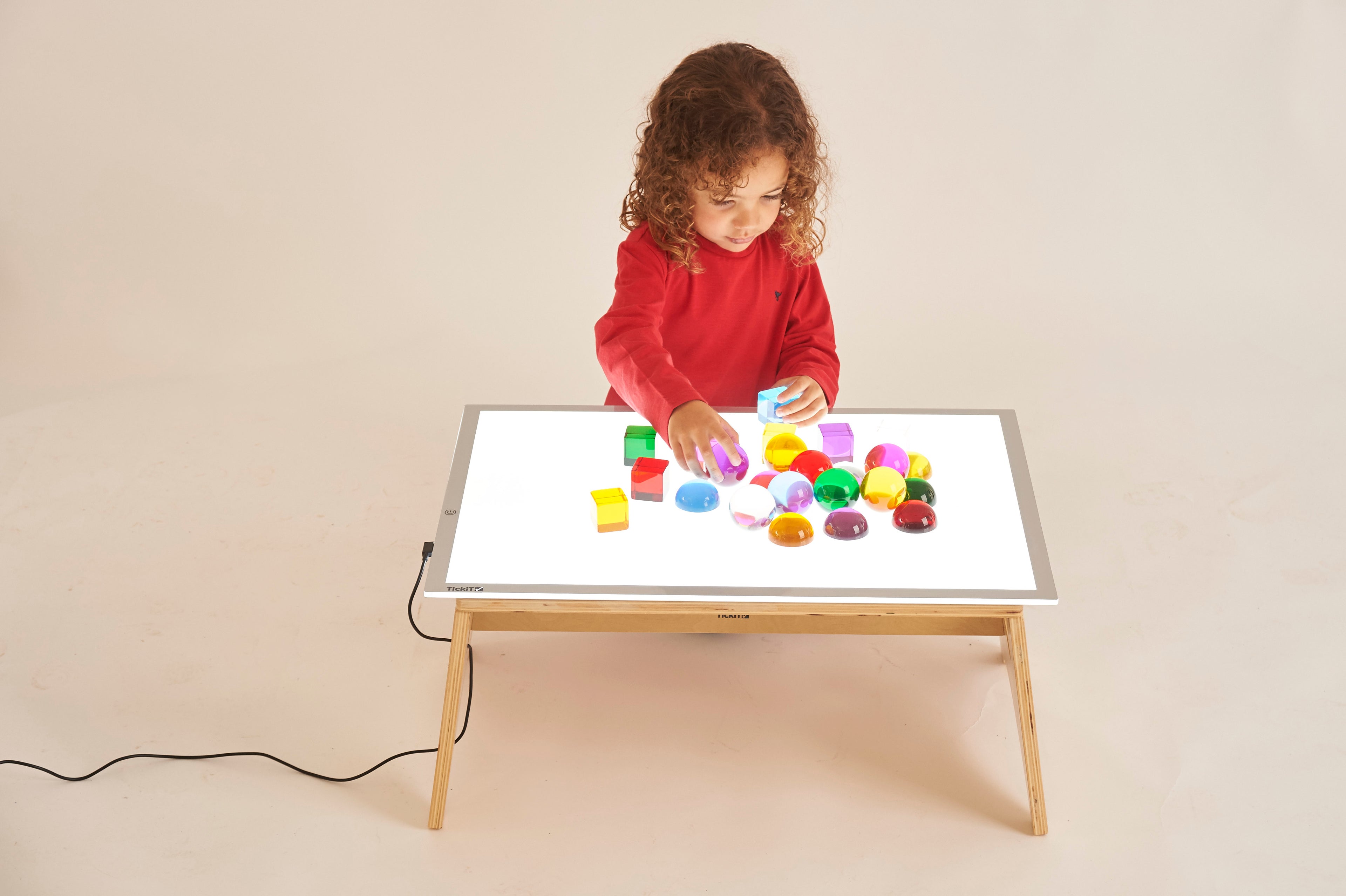 Light panel table with wooden legs and colorful blocks arranged on top