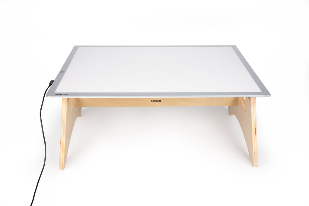 Light panel table set with white lit panel, light wood legs, and power cable
