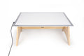 Light panel table set with white lit panel, light wood legs, and power cable
