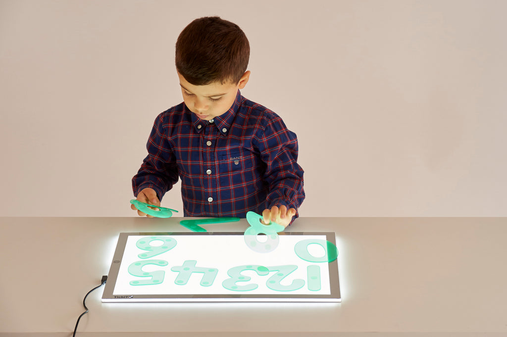 A3 light panel with boy coloring over a bright number grid display