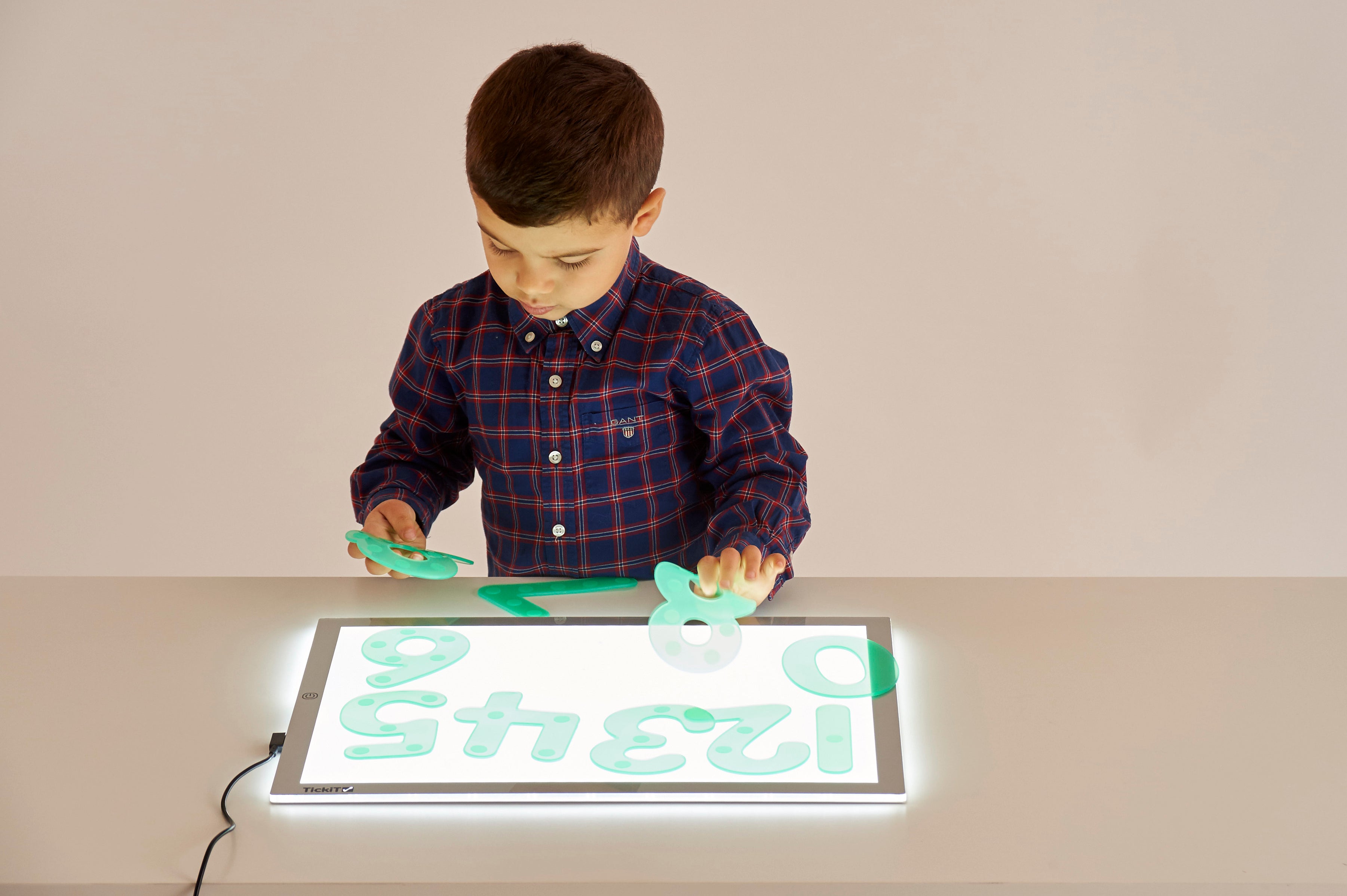 A3 light panel with boy coloring over a bright number grid display