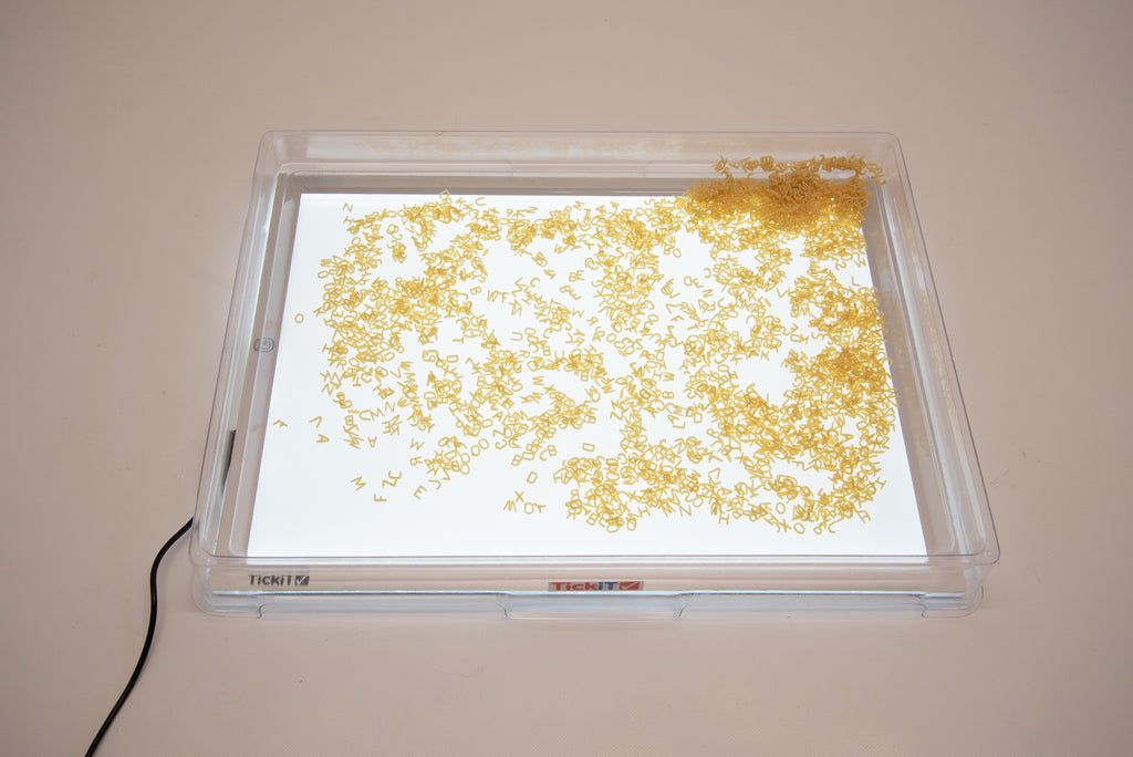 Clear A3 light panel cover showing scattered gold confetti on light surface.