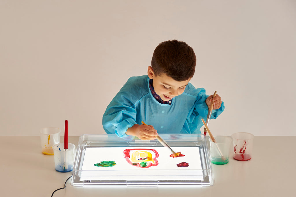 Clear A3 light panel cover with child painting, overhead view of transparent tray.