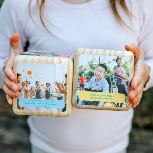 Acts of Kindness dice set showing photo quote faces, held in two hands