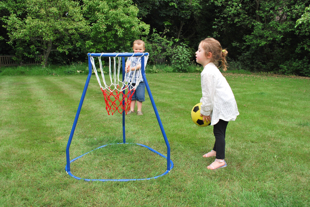 Blue basketball hoop stand with red net in a yard, child holding a yellow ball