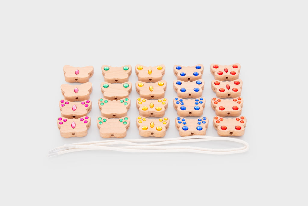 Grouped colorful lacing charms with white cord, front view