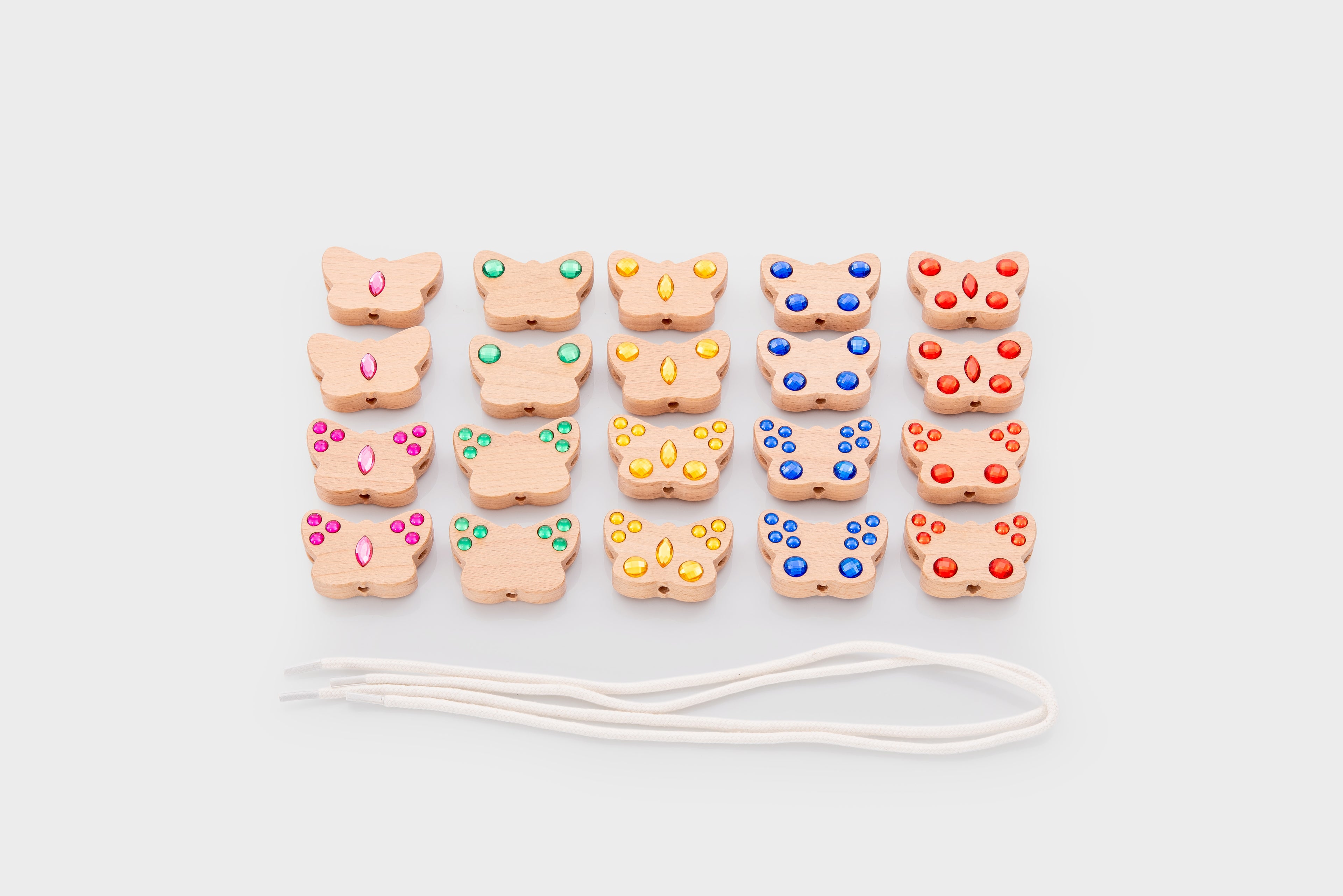 Colorful lacing bead charms with white cord, neatly arranged side by side