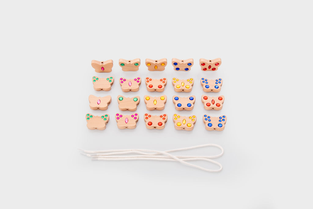 Small shaped lacing charms with white cord on a clean flat surface