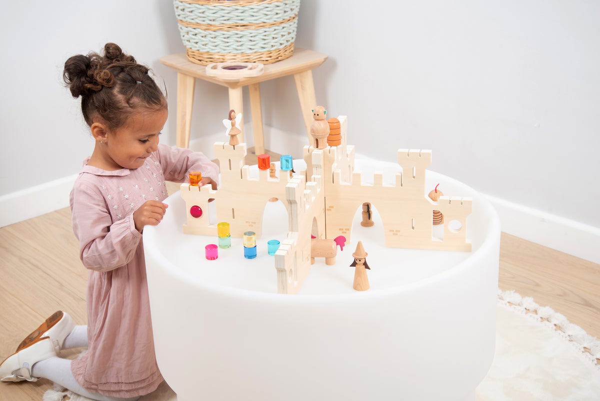 White castle divider playset with small colorful figures and accessories on a round mat