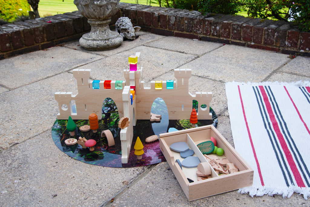 Outdoor castle divider playset with colorful accessories on a round base and tray