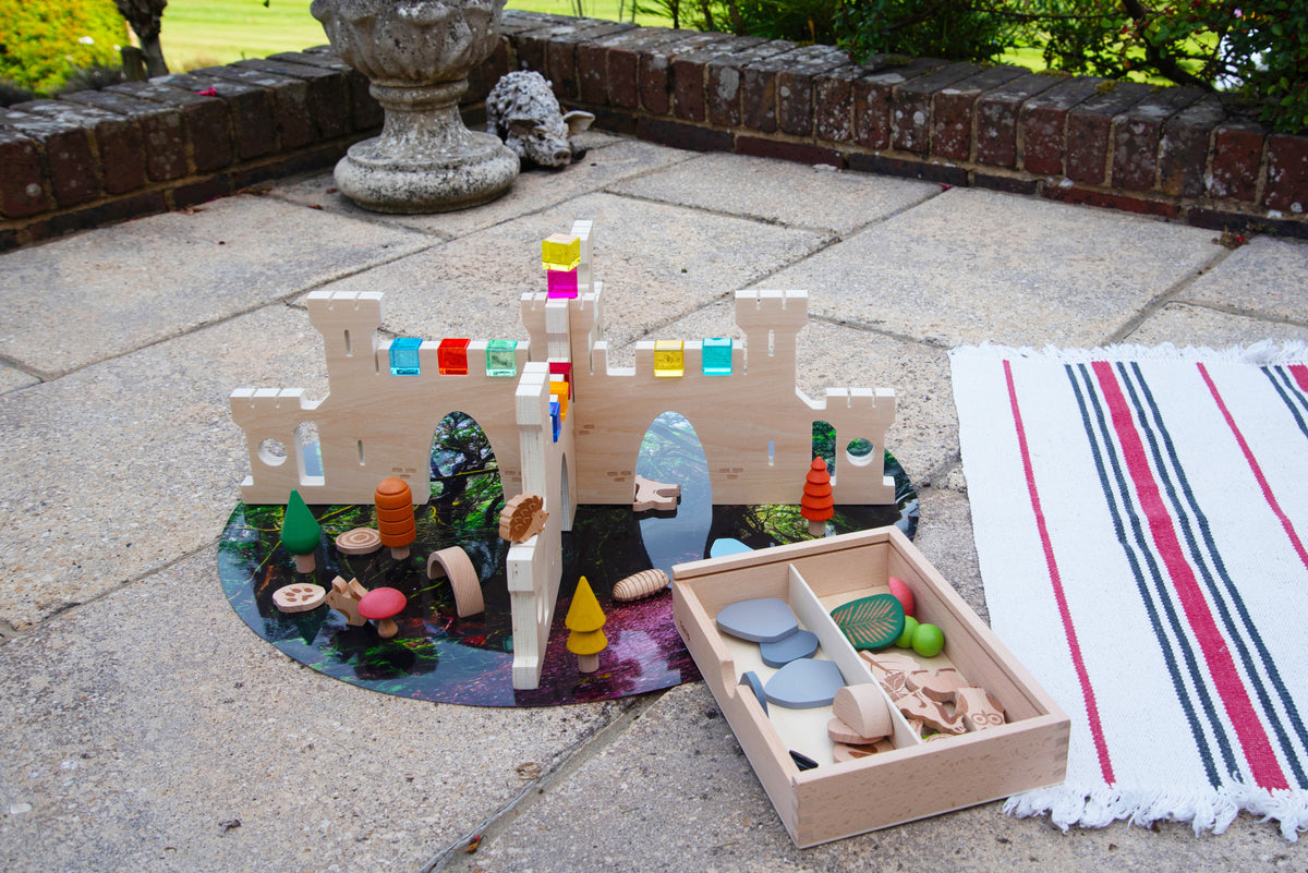 Outdoor castle divider playset with colorful accessories on a round base and tray