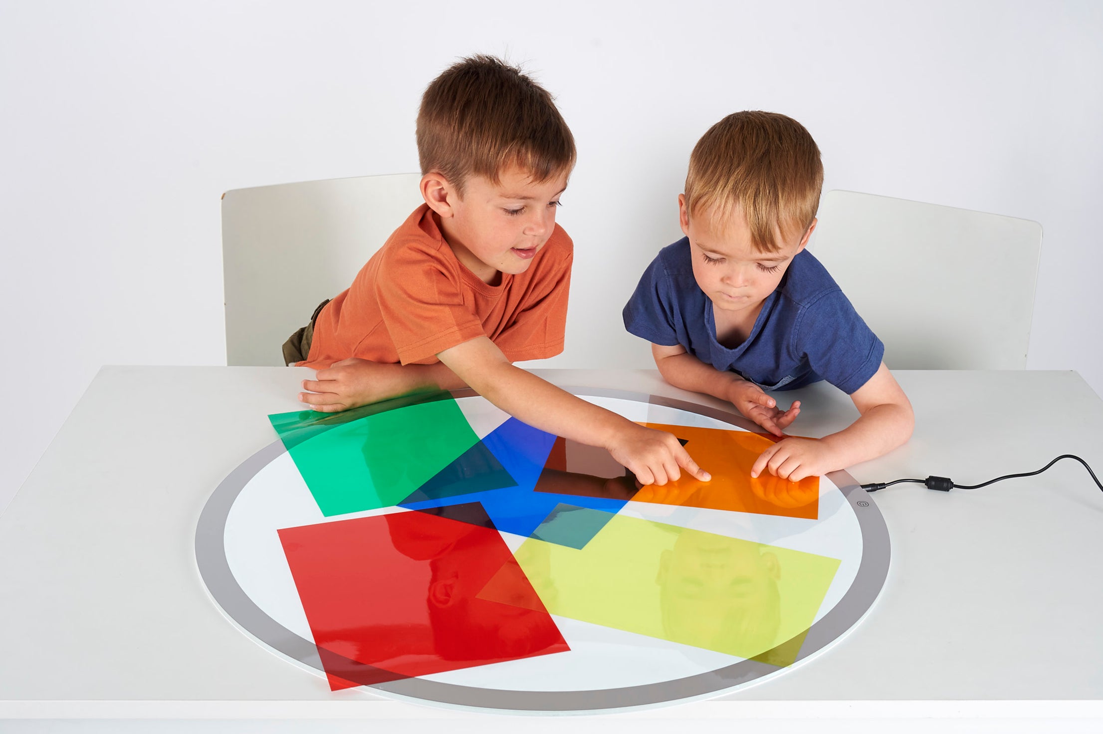 Colored acetate sheets with kids stretching and sliding green, blue, red, and yellow pieces