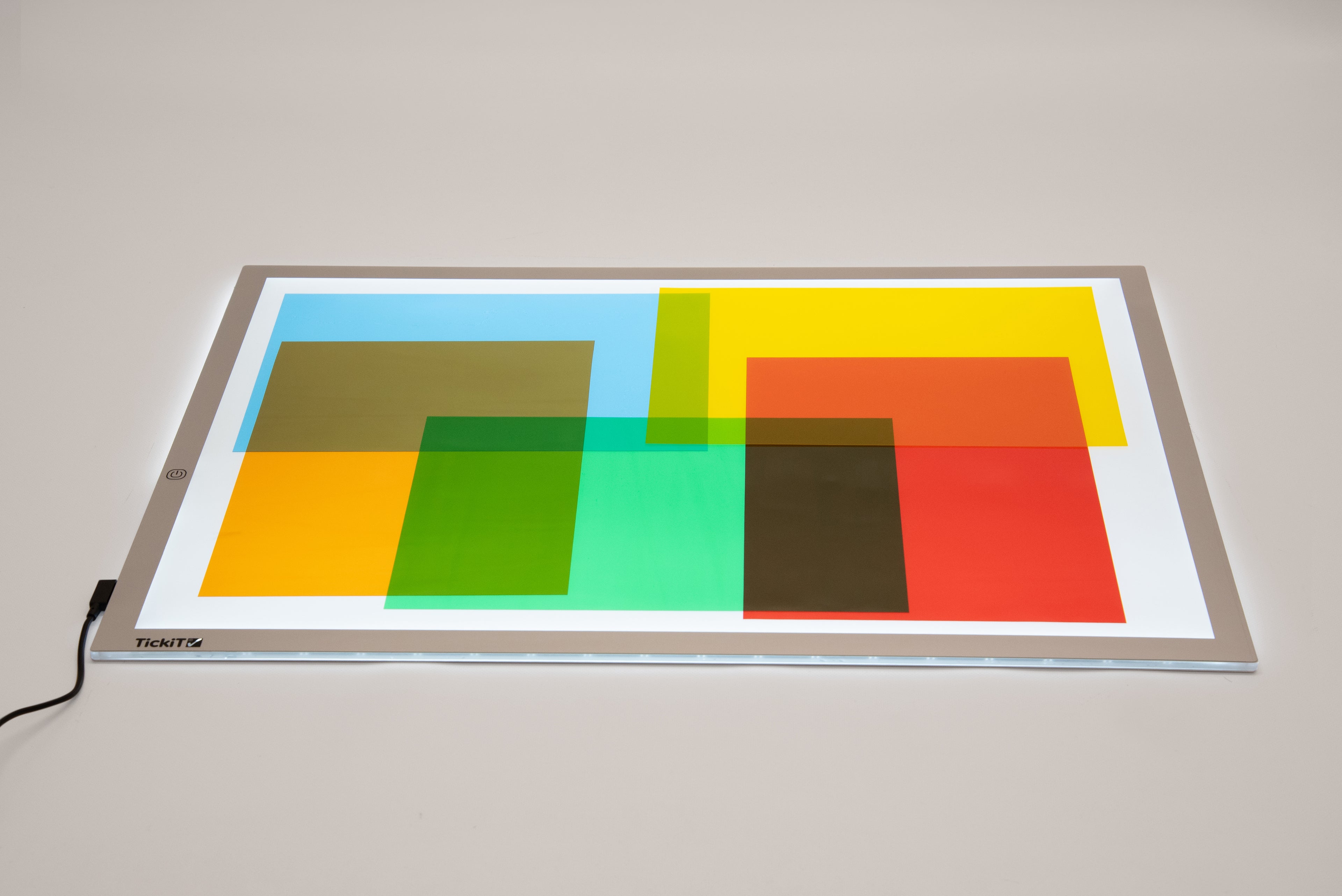Colored acetate sheets on a lighted tray, geometric transparent panels in bright blocks