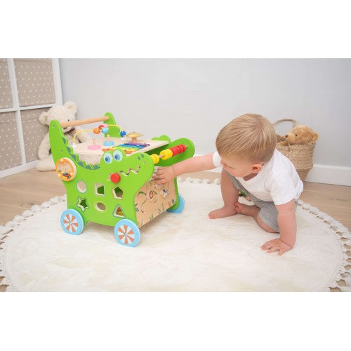 Green activity walker with side activity board, bead maze, and four blue-spoked wheels