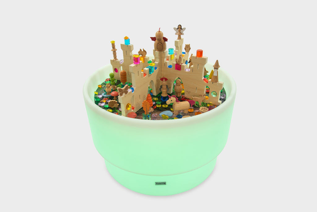 Green illuminated discovery castle play table filled with colorful figures and castle parts