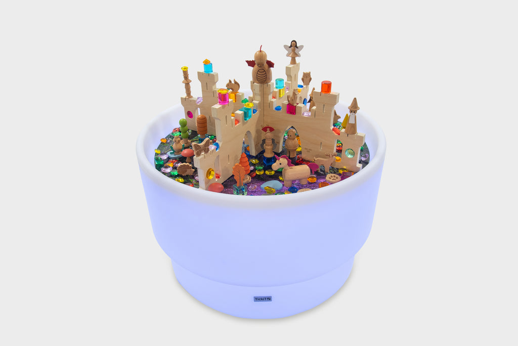 Blue illuminated discovery castle play table filled with colorful figures and castle parts