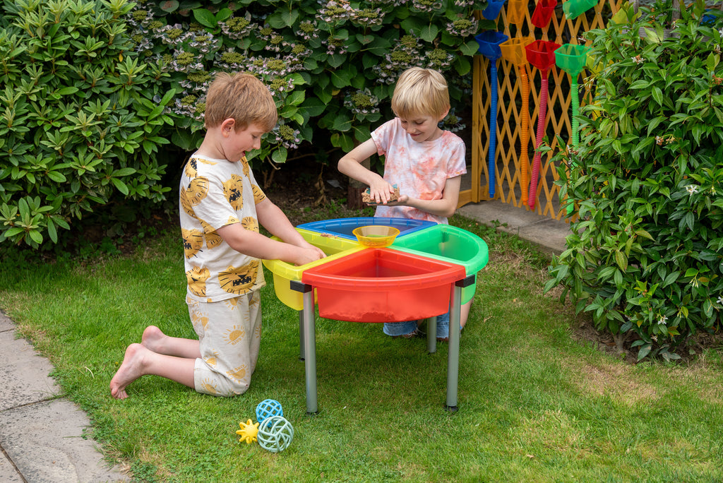 Quadrant color tray set with stand beside garden plants, red and green sand bins