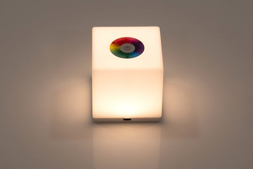 Mini cube LED lamp glowing warm white with circular top lens