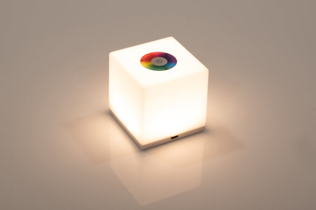 Mini cube LED lamp glowing bright white with circular top lens
