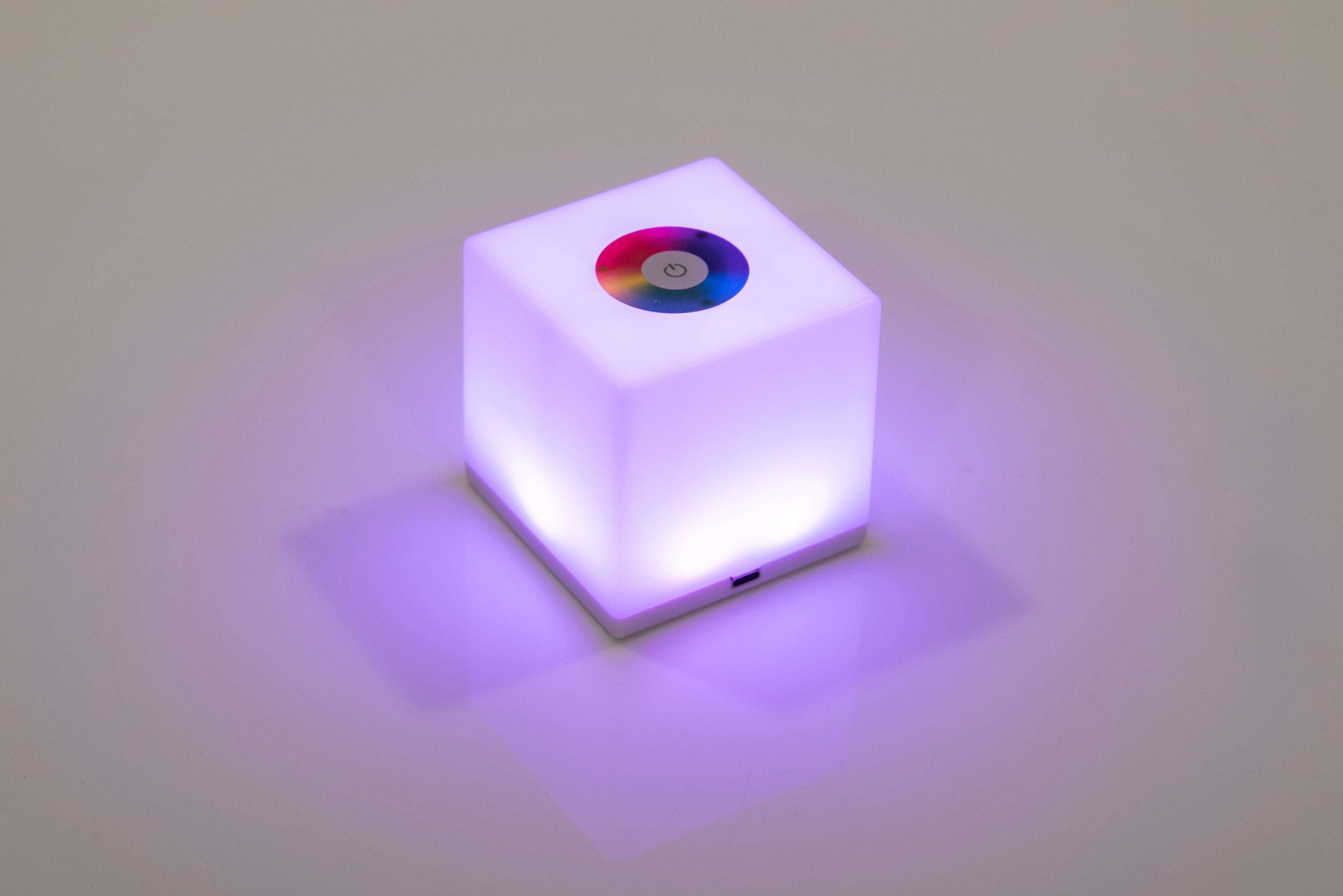 Mini cube LED lamp glowing purple with circular top lens