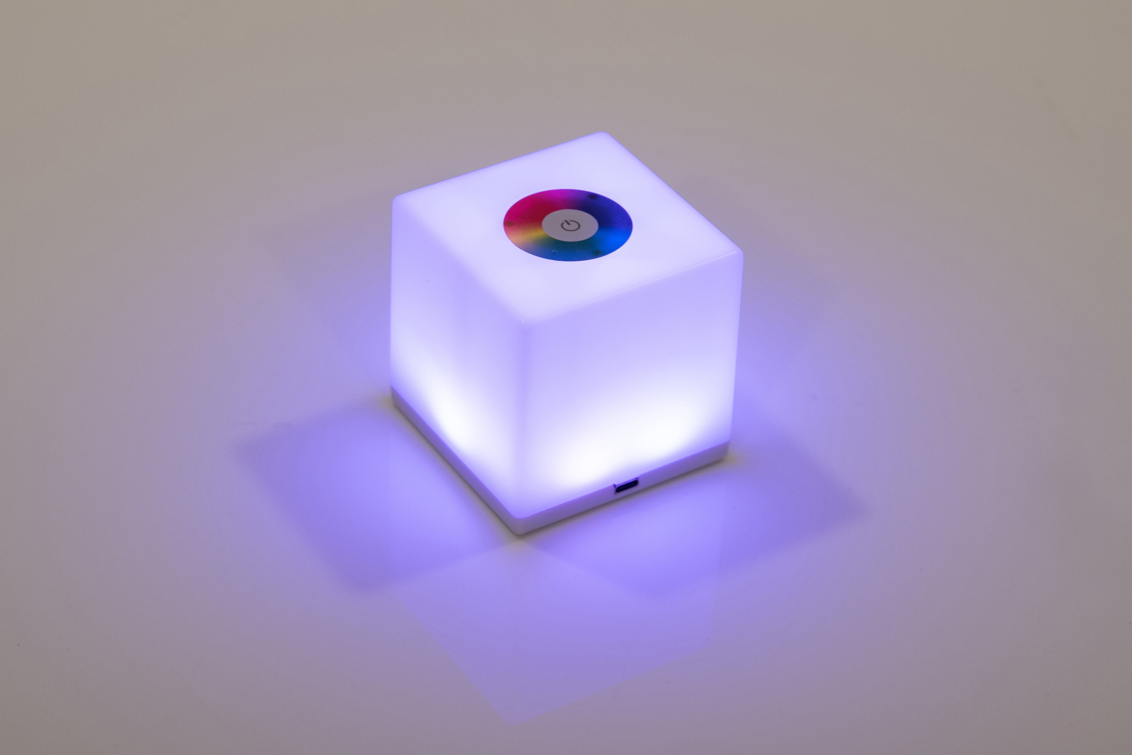 Mini cube LED lamp glowing purple-blue with circular top lens