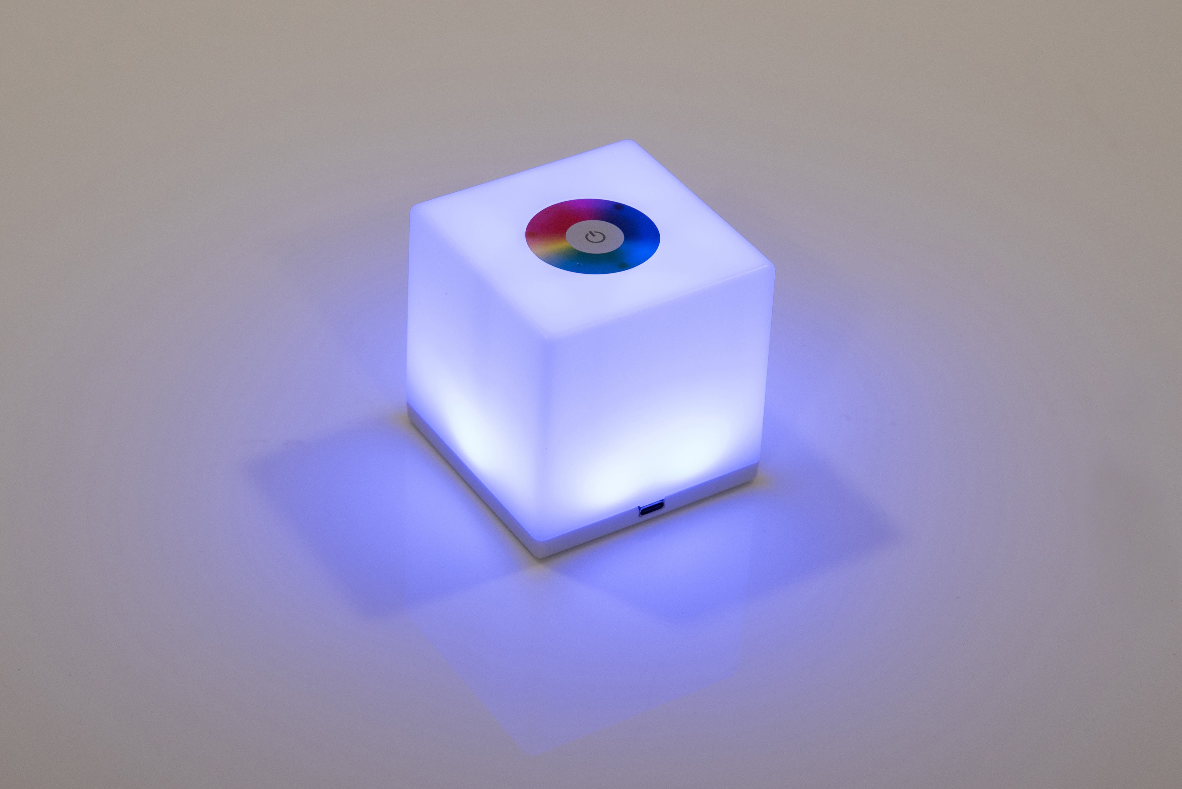 Mini cube LED lamp glowing purple with circular top lens