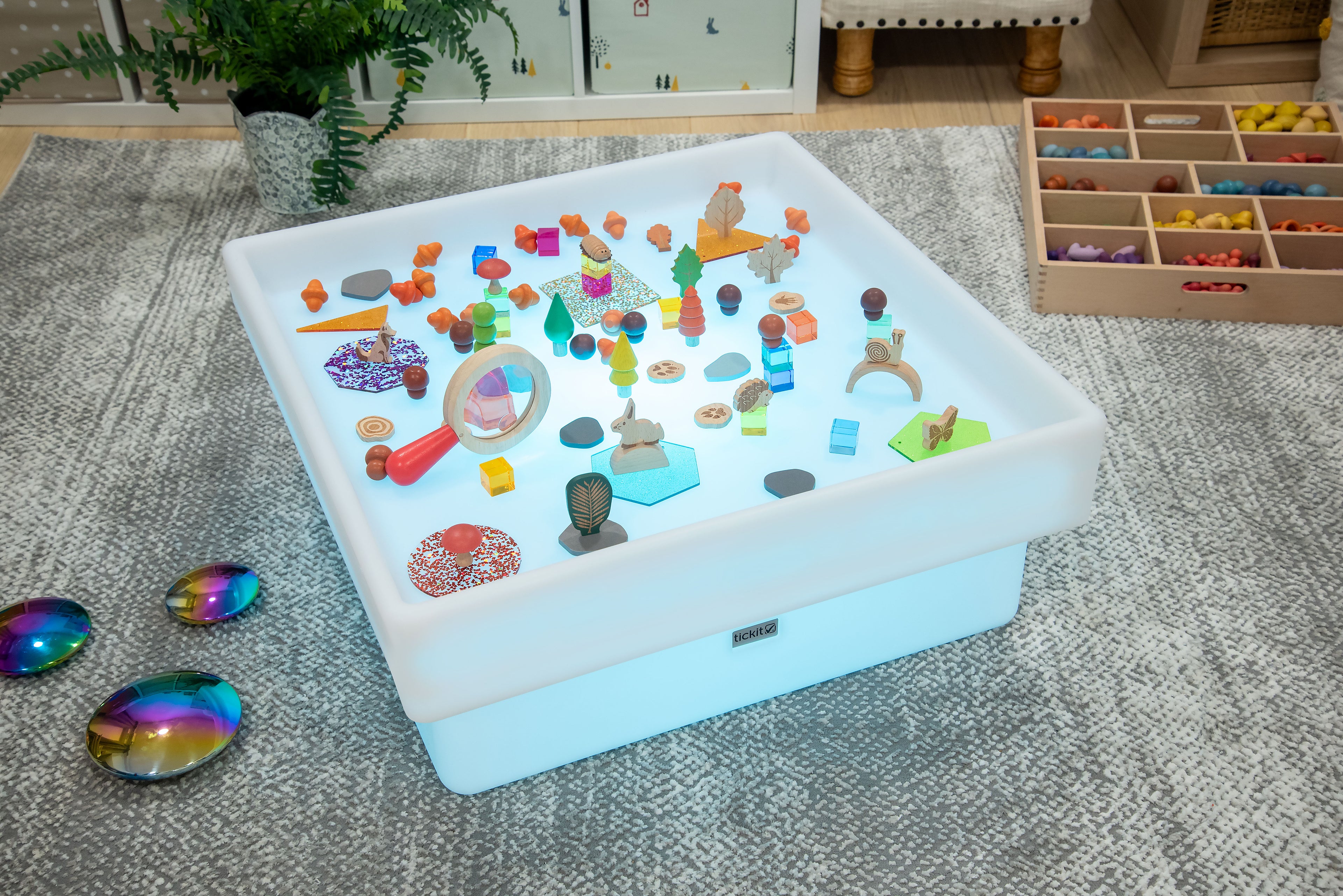 Square glow play table with white tray, scattered colorful toys, and glow