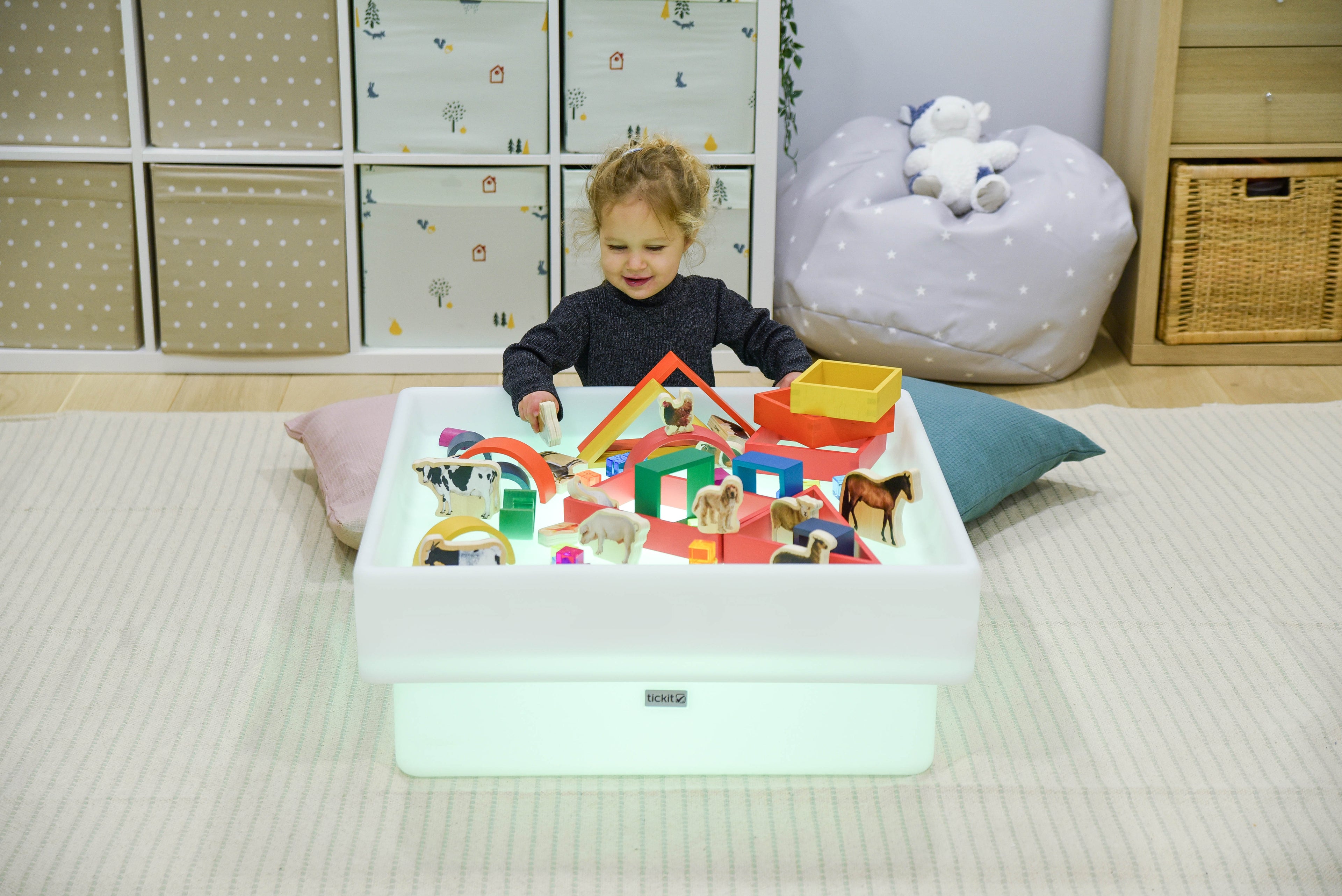 Square glow play table with white tray holding colorful toy figures