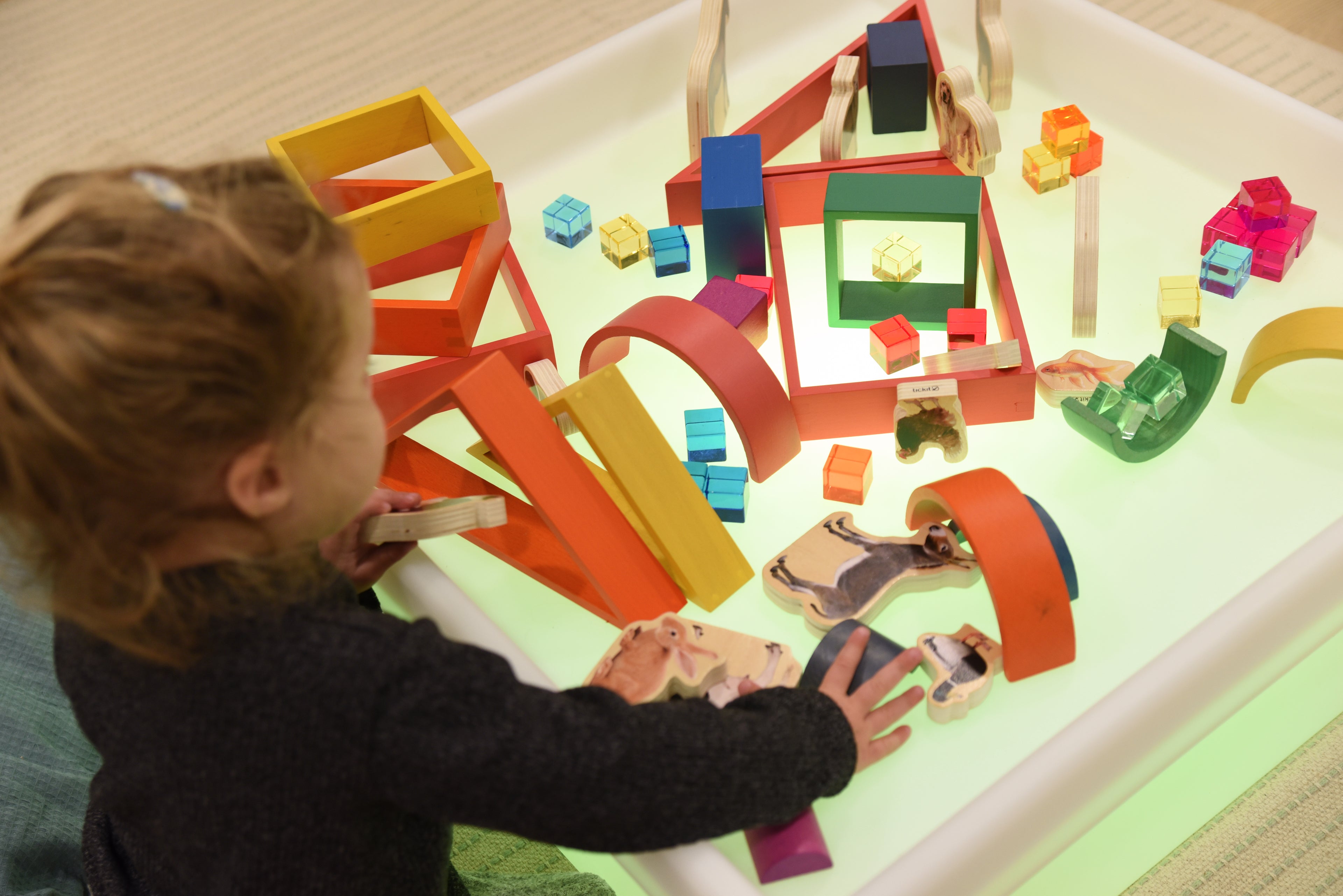 Square glow play table with white tray and colorful block train layout