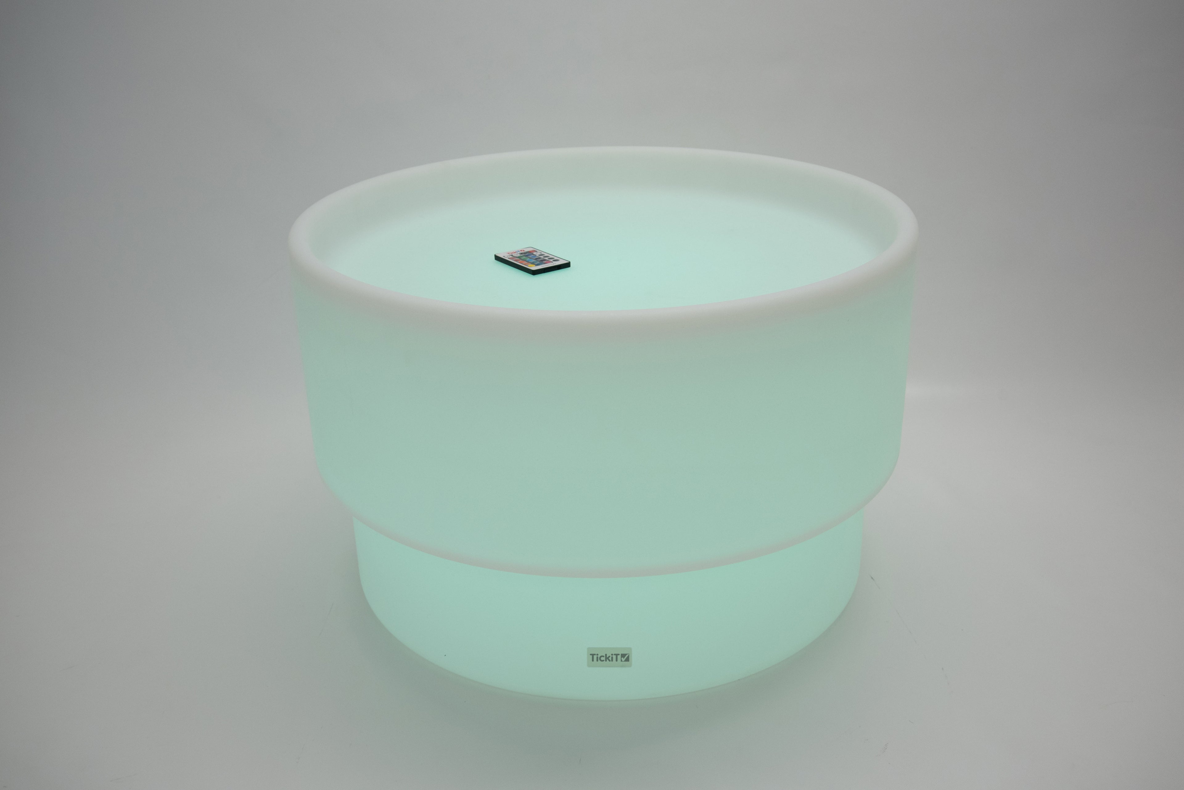 Round tabletop light, mint green glow with white rim and small top emblem