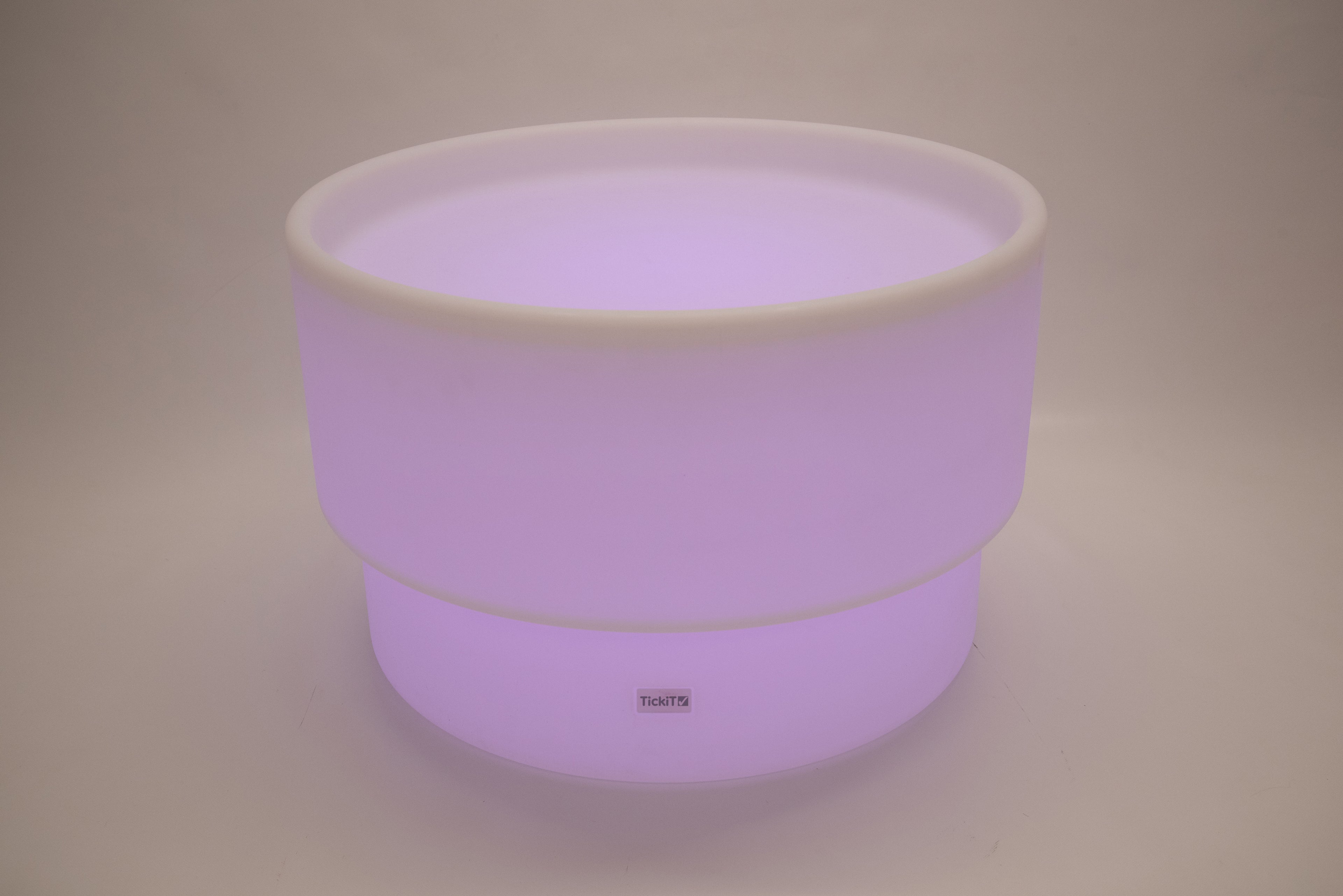 Round tabletop light, lavender glow with white rim and smooth cylindrical body