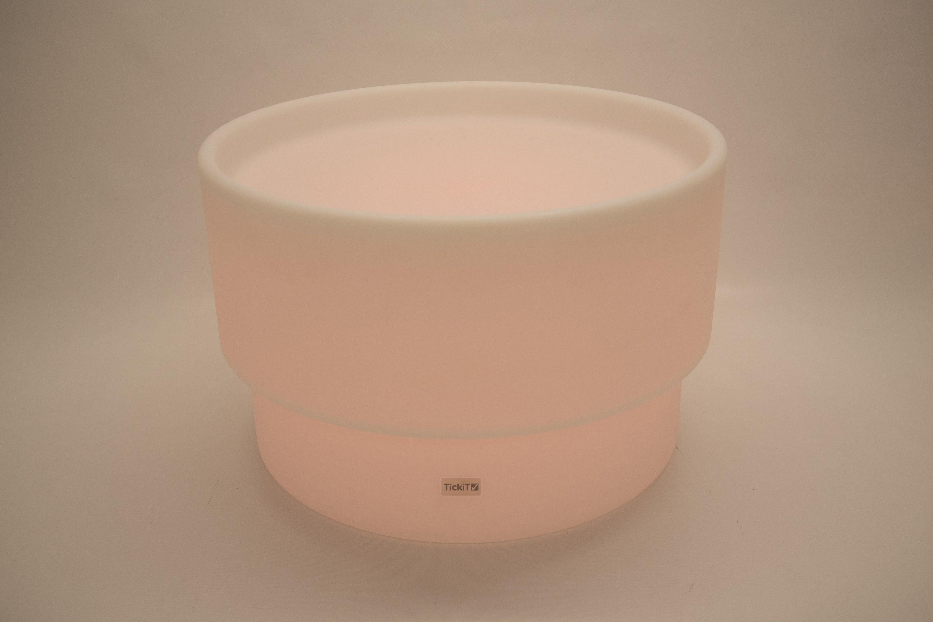 Round tabletop light, soft peach glow with white rim and smooth cylindrical base