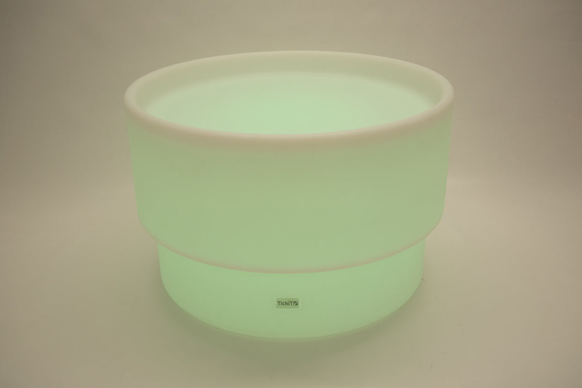 Round tabletop light, pale green glow with white rim and smooth cylindrical body