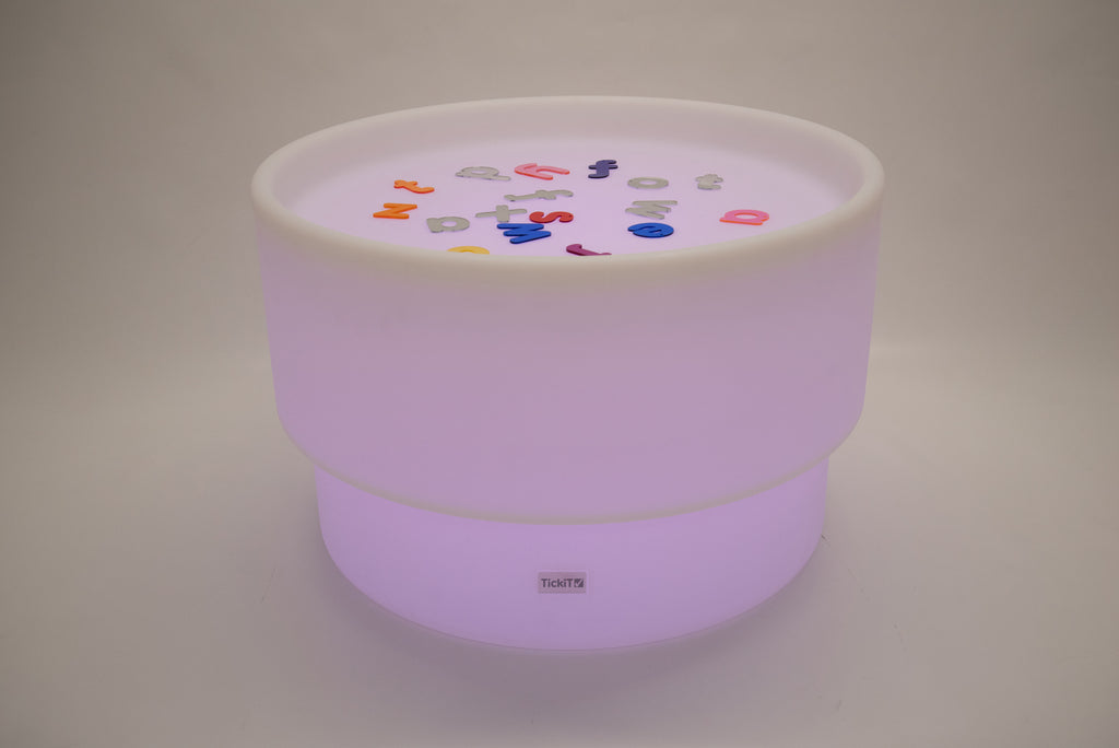 Round tabletop light with purple glow and colorful pieces on the top surface
