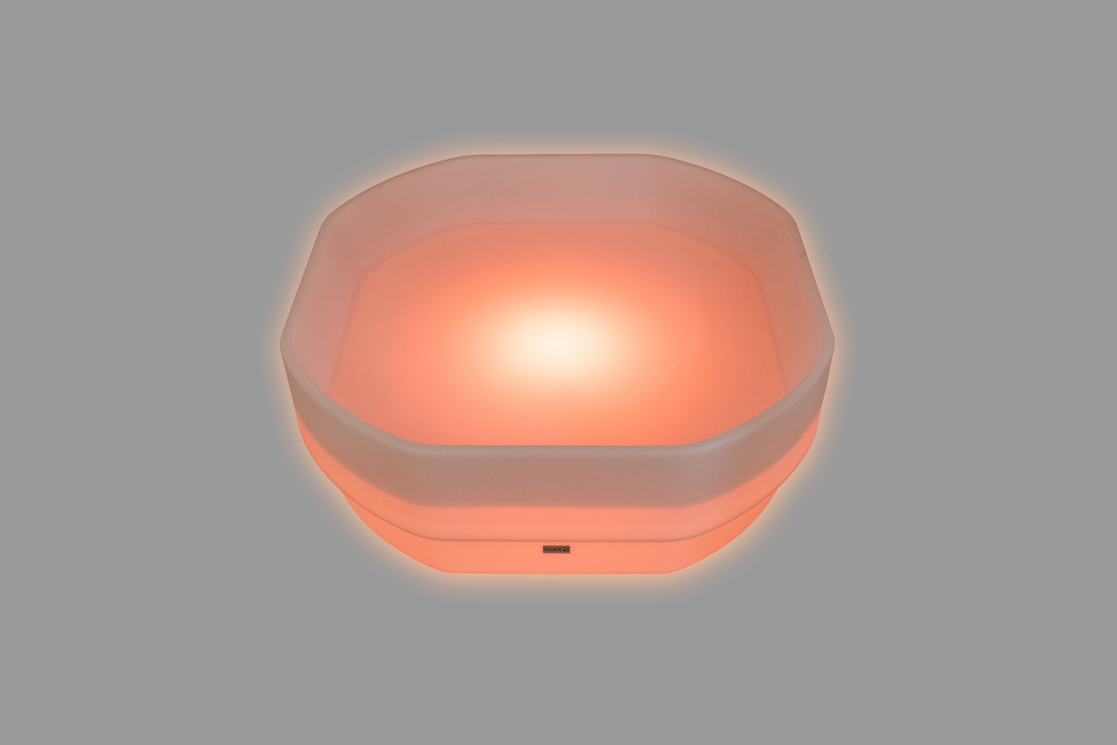 Hexagonal LED glow table with pink-orange light and translucent sides