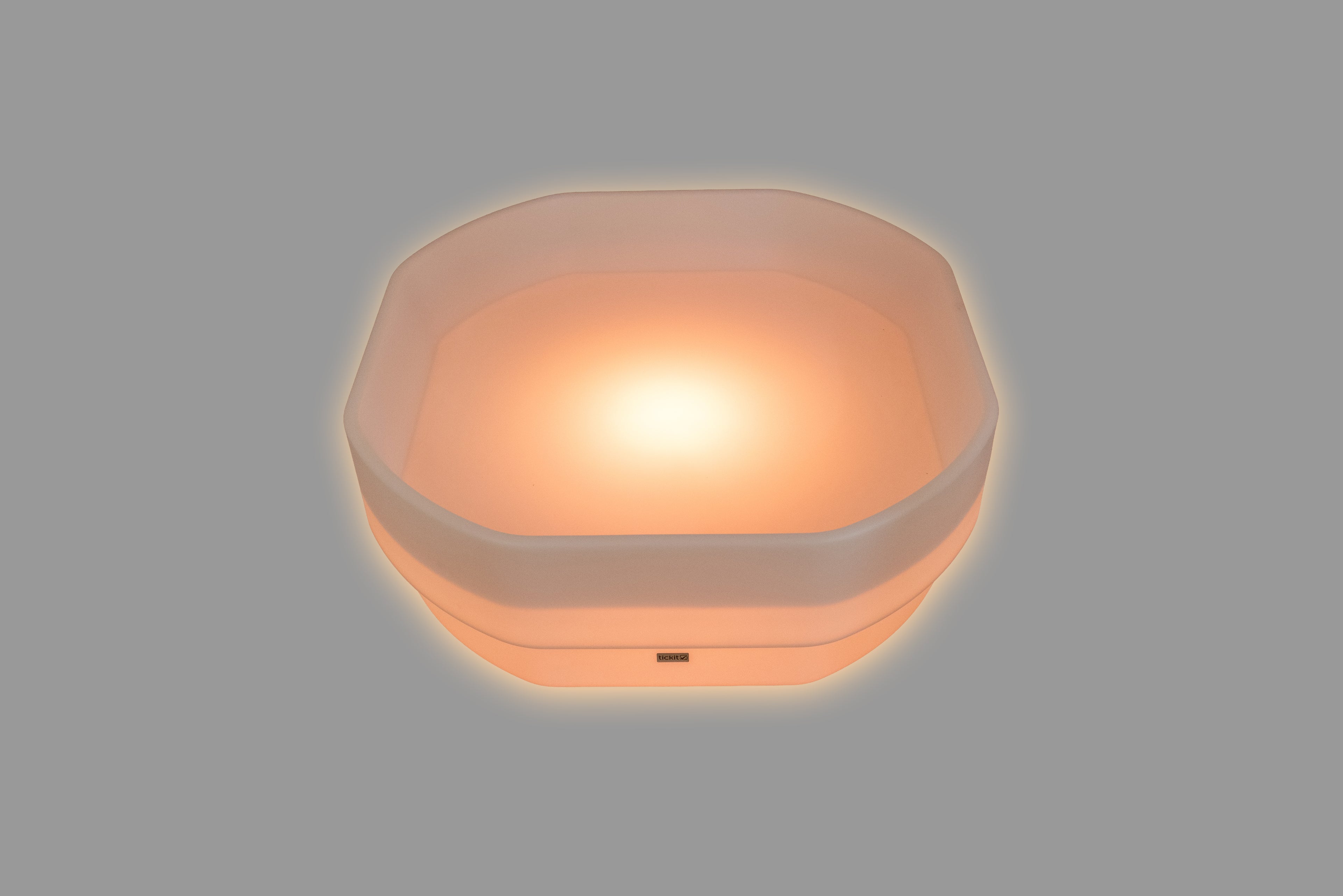 Hexagonal LED glow table with soft orange light and translucent shell