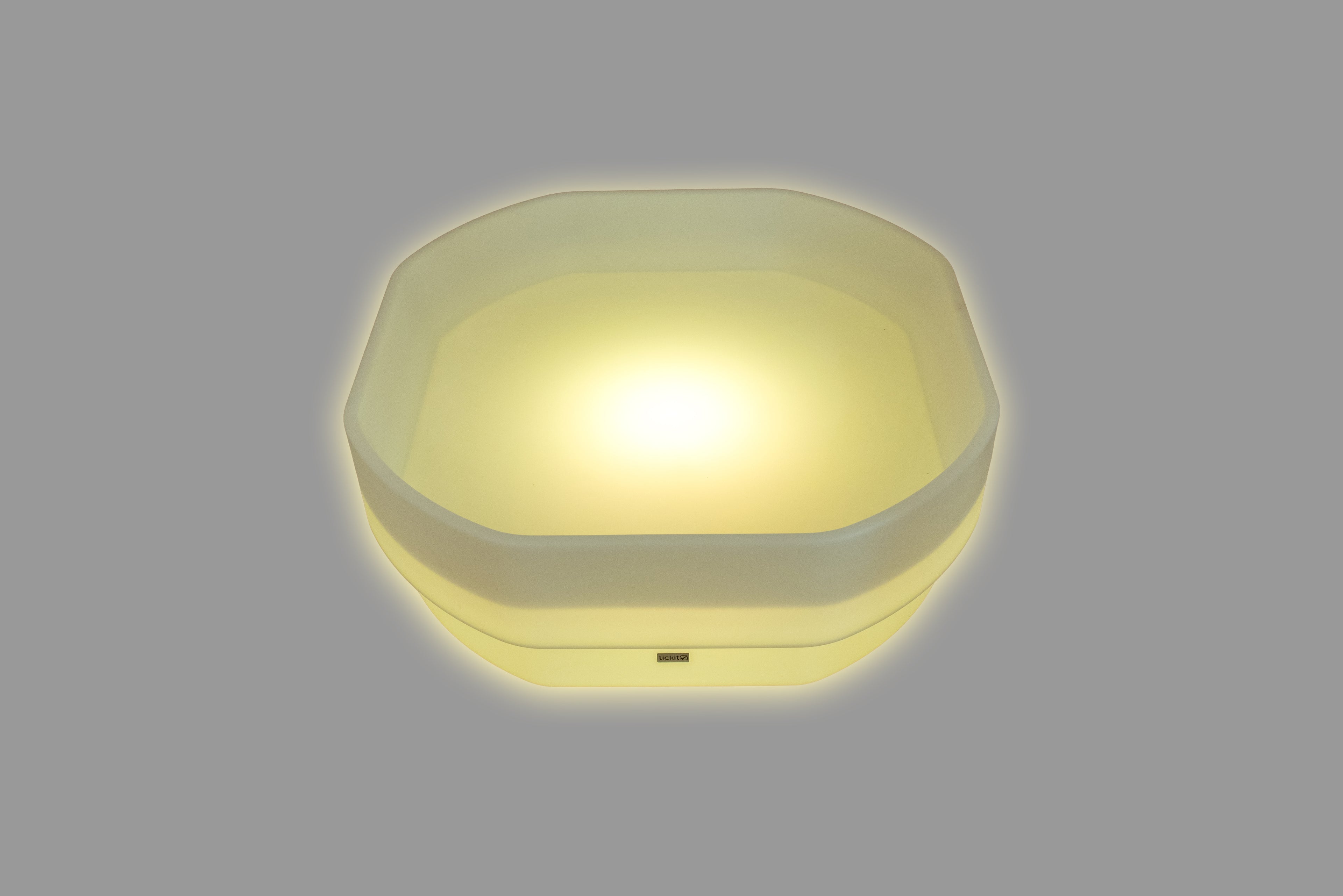 Hexagonal LED glow table with warm yellow light and translucent sides