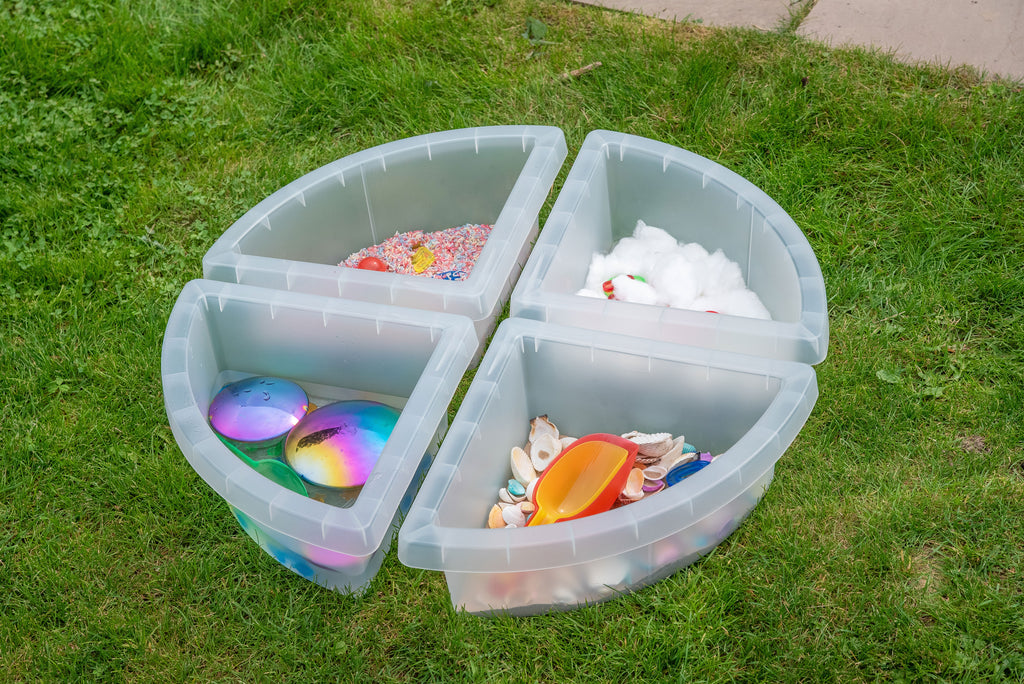 Round clear quadrant tray with four sections, holding assorted colorful sensory items