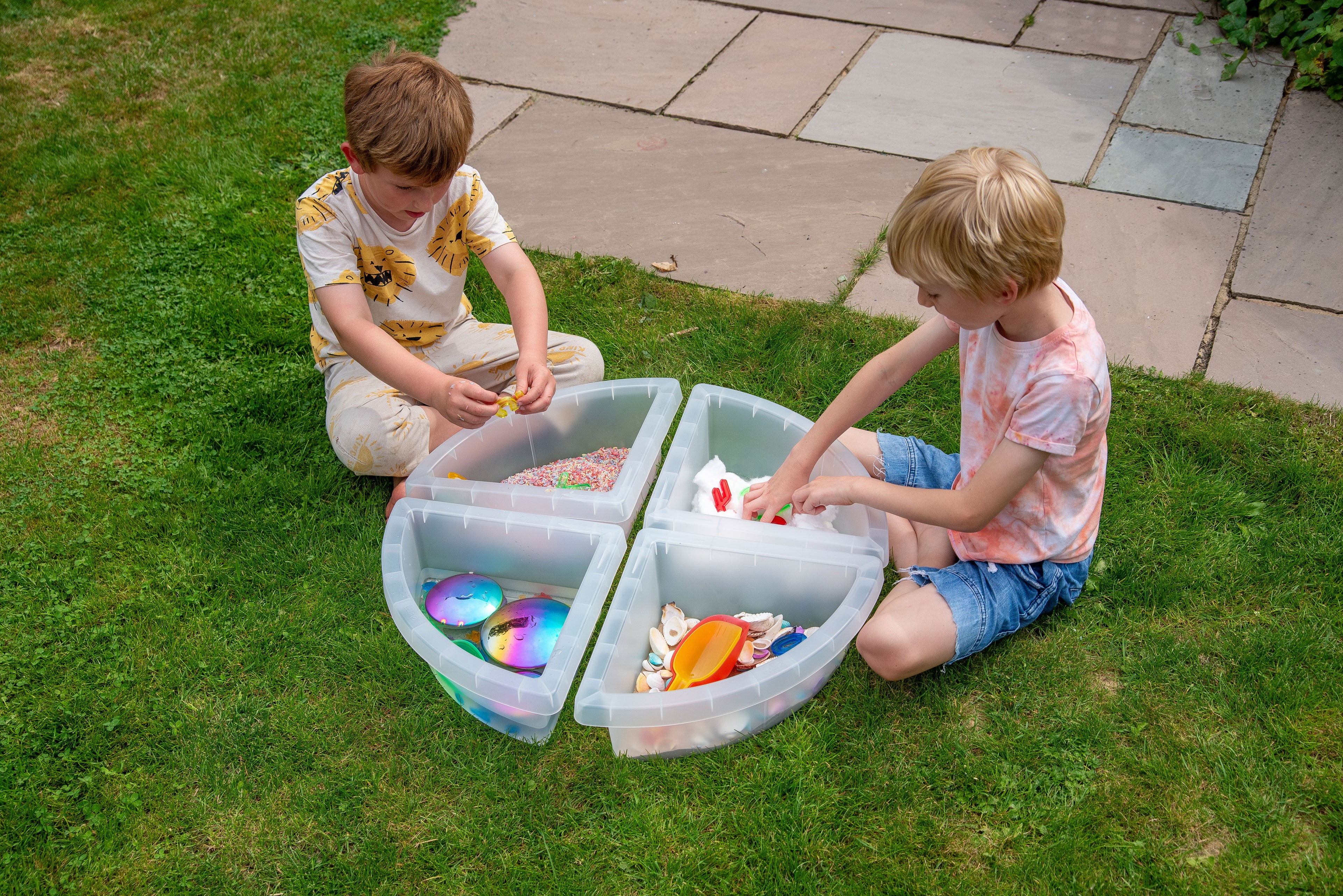 Four-compartment round sensory tray with colorful items, divided sections for sorting