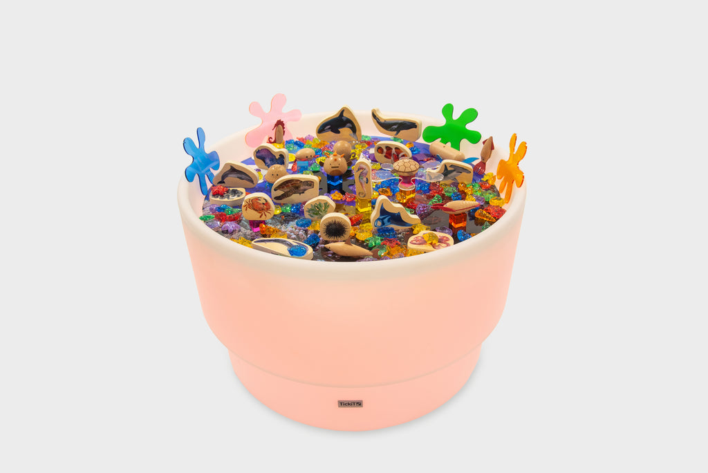 Pastel peach sea-themed table bundle filled with ocean animal toys and shells
