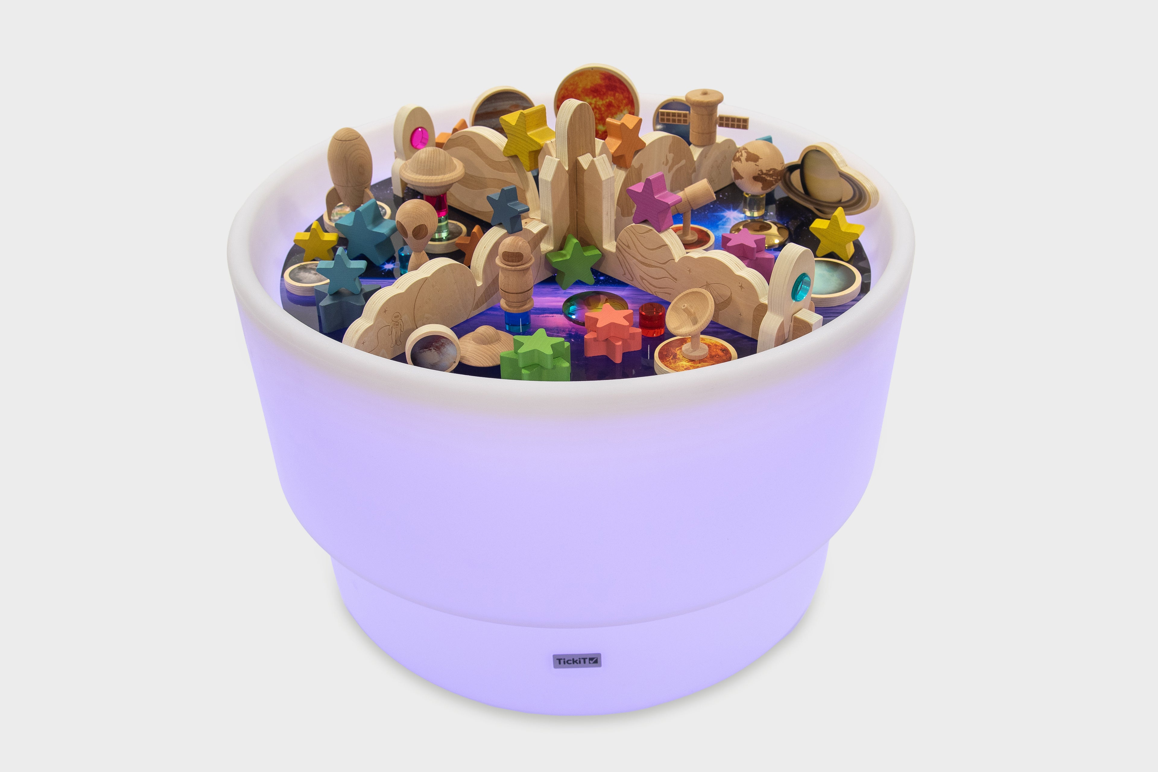 Purple glowing space play table filled with colorful wooden space pieces